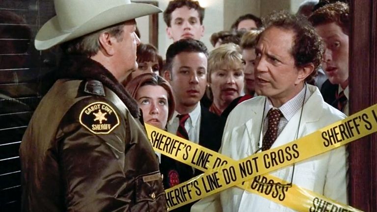 Sheriff behind 'Do Not Cross' tape with a crowd trying to get through